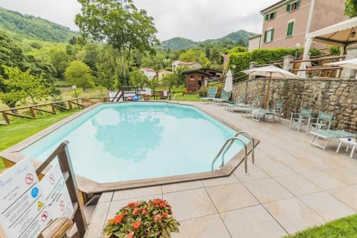 uma piscina num resort com montanhas ao fundo em Schöne und sehr gut eingerichetete Ferienwohnung mit privater Terrasse, Pool,Grillplatz,ruhig gelegen em Pistoia