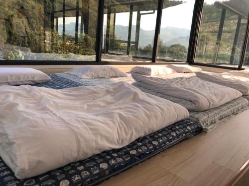 duże łóżko na podłodze w pokoju z oknami w obiekcie Bao Chi B&B w mieście Fanlu