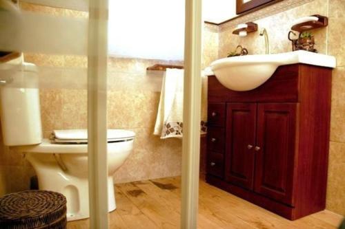 ein Badezimmer mit einem Waschbecken, einem WC und einem Spiegel in der Unterkunft Ferienhaus für 6 Personen ca 140 m in Porto do Son, Costa Verde Spanien Rías Baixas in Porto do Son