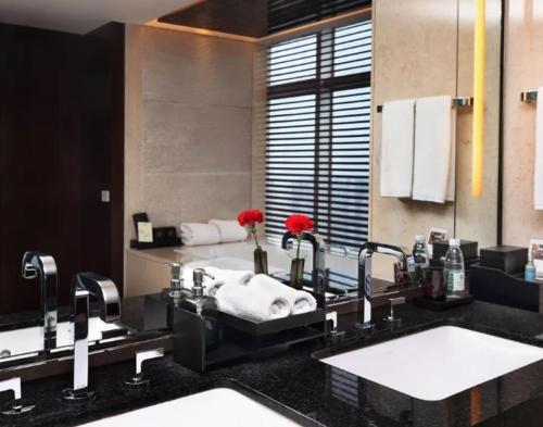 een badkamer met 2 wastafels en 2 kranen bij Nanyuan Universe Deluxe Hotel in Ningbo