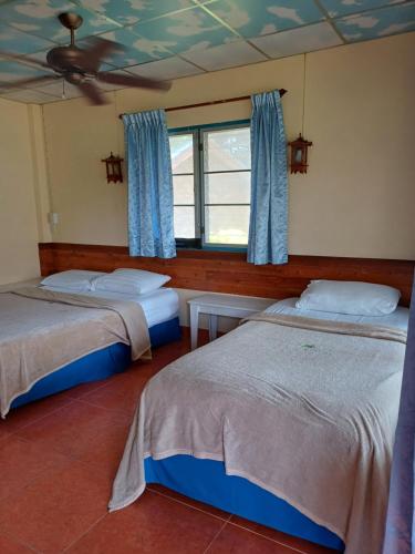 a bedroom with two beds and a window at Tropicana Khophagan Resort Hotel in Thongsala