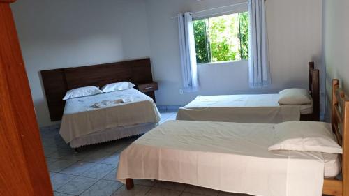 um quarto com 2 camas e uma janela em Hotel Turazzi em Cáceres