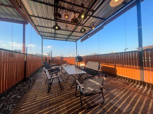 a balcony with a table and chairs on top of a building at 4 Bedroom House with Beautiful Rooftop near BTS Ekkamai in Bangkok