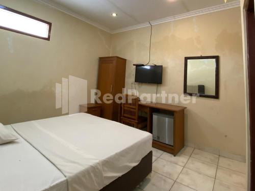 a bedroom with two beds and a tv and a mirror at Hotel Kurnia @ Jln Pemuda Blora RedPartner in Blora
