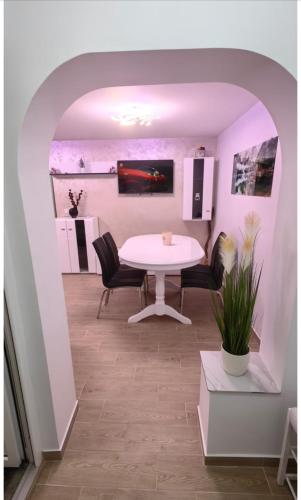 comedor con mesa blanca y sillas en Luxury apartament, en Fălticeni