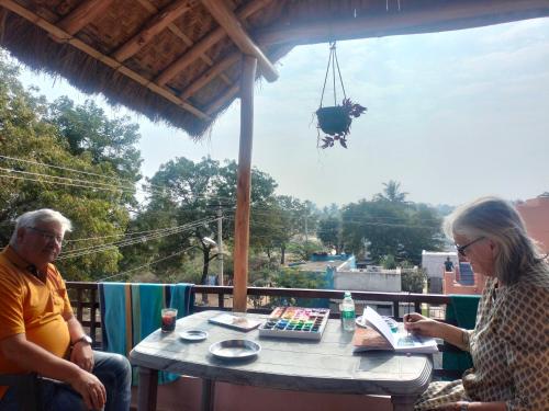 a man and a woman sitting at a table at Prajwal home stay in Hampi