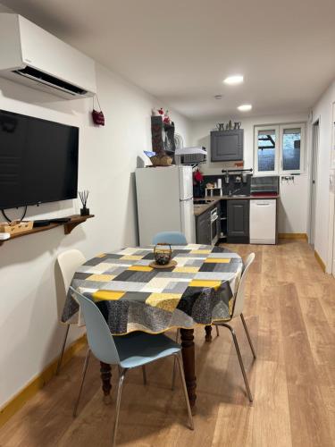 eine Küche und ein Esszimmer mit einem Tisch und Stühlen in der Unterkunft Les Gîtes de la Bergerie - Boule de Neige in Meximieux
