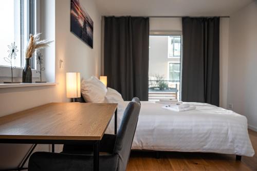sypialnia z łóżkiem, stołem i oknem w obiekcie ApartHome - LUXUS PUR auf 91m2 Klima w mieście Eching
