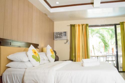 two beds in a room with a window at Boracay Peninsula in Boracay