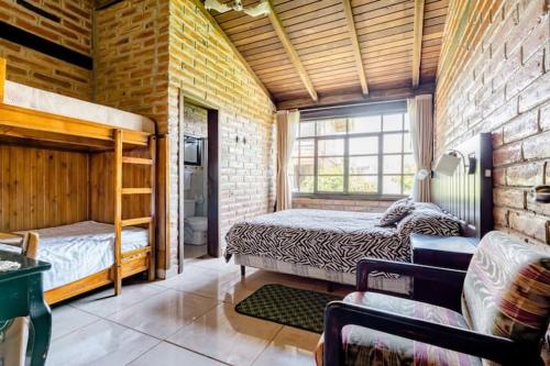 1 dormitorio con cama y pared de ladrillo en Quinta María Alfonsina, en Ibarra