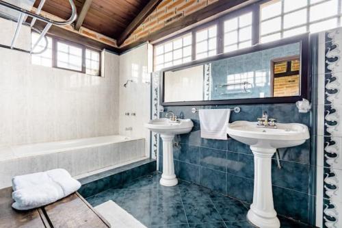 y baño con 2 lavabos y bañera. en Quinta María Alfonsina, en Ibarra