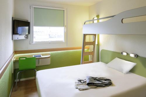 a bedroom with a bed and a bunk bed at ibis budget Zurich Airport in Glattbrugg