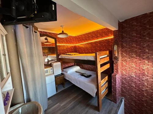 a small room with two bunk beds in a brick wall at Penthouse TJ in Tijuana
