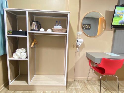 a white cabinet with a desk and a red chair at S1 City Hotel Buriram in Buriram