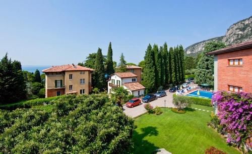 un groupe de maisons et une cour avec une piscine dans l'établissement Hotel Gabbiano - Garda Lake Collection, à Garde