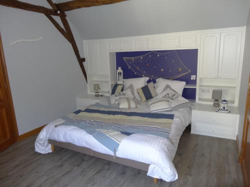 a bedroom with a large bed with pillows on it at Jardin de Canaan in Saint-Julien-de-Chédon