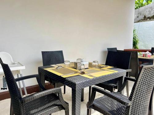 a dining table with chairs and a tableasteryasteryasteryasteryasteryasteryasteryastery at Bougan Villea Retreat in Bodufolhudhoo