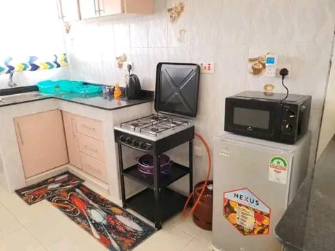 a small kitchen with a stove and a microwave at Safaris hotels in Nairobi