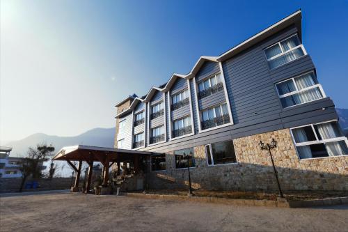 a large building with awning in front of it at Kaizen X Voyage Resort And Spa in Manāli