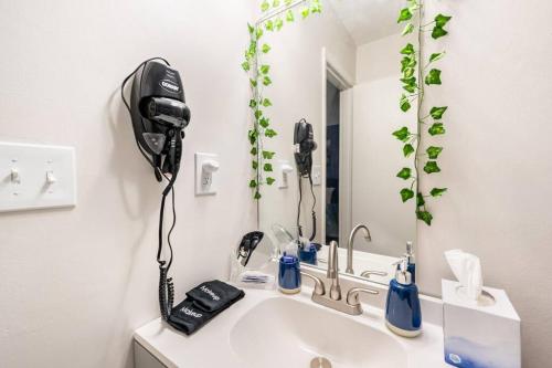 y baño con lavabo y espejo con teléfono. en Escape the City w/King Bed, Arcade Games & Firepit, en Norcross