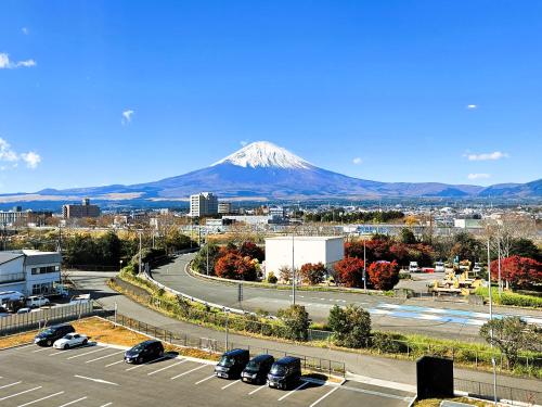 a mountain in the distance with cars parked in a parking lot at The Celecton Fujisan Gotemba Interchange in Gotemba
