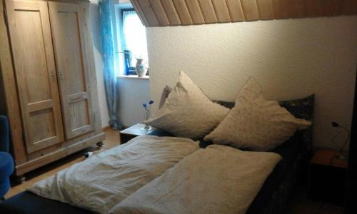 a bed with pillows on it in a bedroom at Zur Alleinnutzung ehemaliges Jagdhaus im Nationalpark Bayerischer Wald in Geiersthal