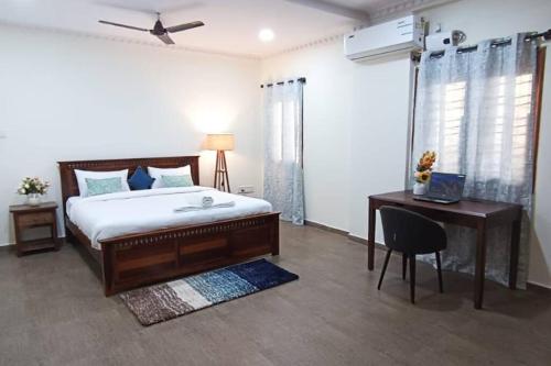 a bedroom with a bed and a desk and a bed and a chair at 4BHK Luxury Apartment at VV Mohalla/Mysore by Revkeys in Mysore