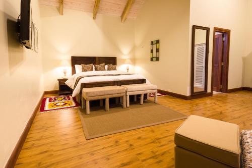 um quarto com uma cama num quarto com pisos em madeira em The Residences at Karen em Nairobi