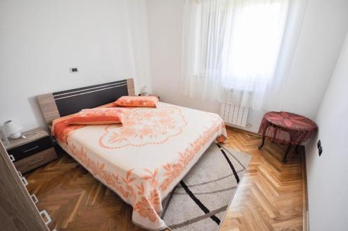 1 dormitorio con 1 cama con manta naranja y blanca en Große Ferienwohnung in Dajla mit Garten und Terrasse, en Dajla