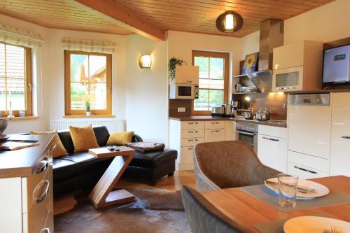 eine Küche und ein Wohnzimmer mit einem Sofa und einem Tisch in der Unterkunft Wohnung in Bach mit Terrasse und Garten in Bad Kleinkirchheim