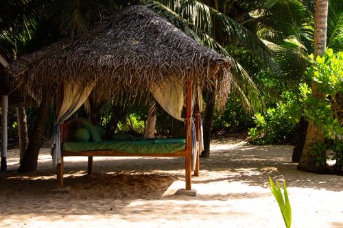 a bed in a straw hut on the beach at Ibisbird Beach Bungalows, Sport, Spa and Restaurant in Tangalle
