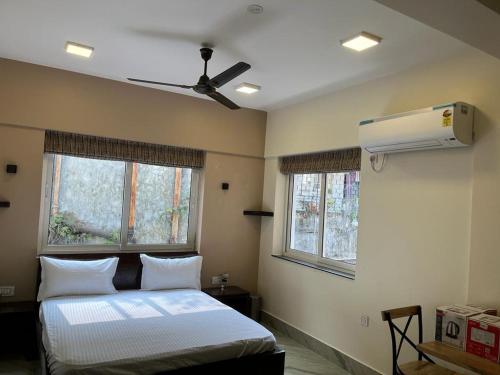 um quarto com uma cama e uma ventoinha de tecto em The Broome Kolkata em Calcutá