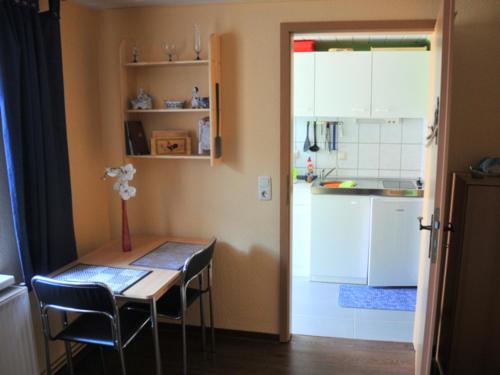 eine Küche mit einem Tisch und Stühlen sowie einem Tisch und einer Küche in der Unterkunft Ferienwohnung Neuendorf in Neuendorf