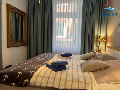 ein Schlafzimmer mit einem Bett mit zwei Kissen darauf in der Unterkunft Pension Marie Luise 251 - Zimmer Herzmuschel in Juist