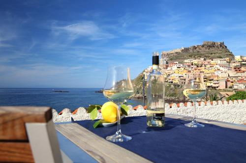 a table with two glasses of wine and a bottle at Hotel Meli in Castelsardo