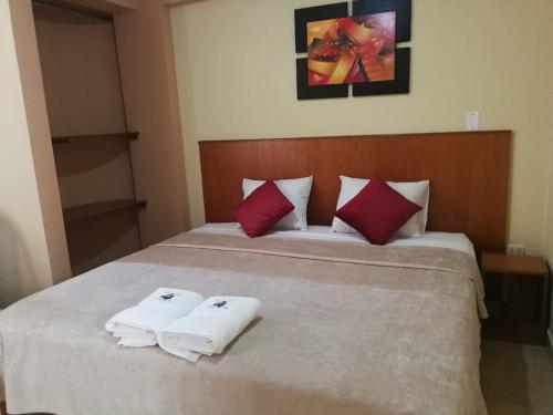 a bedroom with a bed with two towels on it at Hostal Aventura Total Perú_lunahuana in Lunahuaná