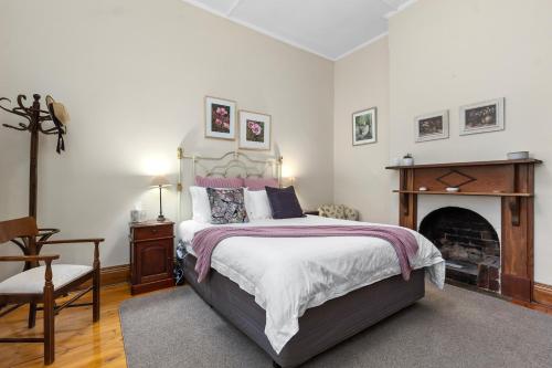 a bedroom with a large bed and a fireplace at Miriams Cottage in Tanunda