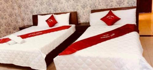 2 camas en una habitación con almohadas rojas y blancas en Phát Thịnh Hotel, en Ho Chi Minh