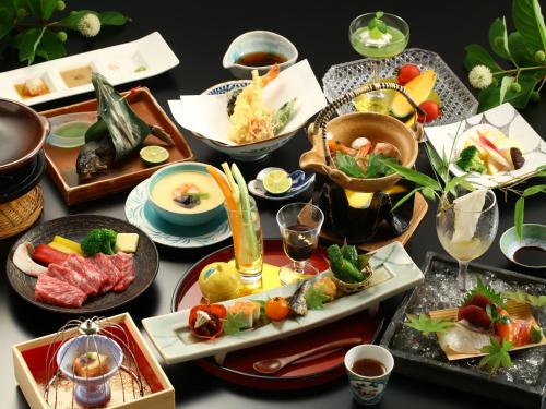 una mesa con muchos platos de comida. en 別所温泉 七草の湯, en Ueda
