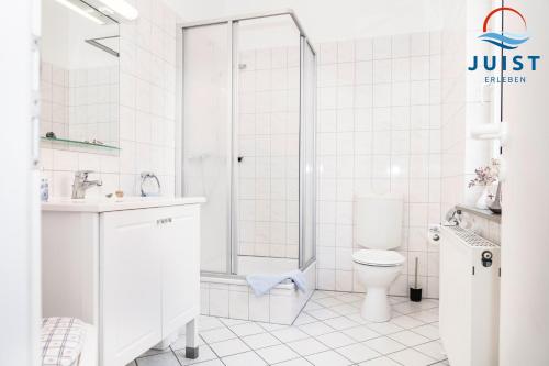 a white bathroom with a shower and a toilet at Pension Marie Luise 254 - Zimmer Jacobsmuschel in Juist