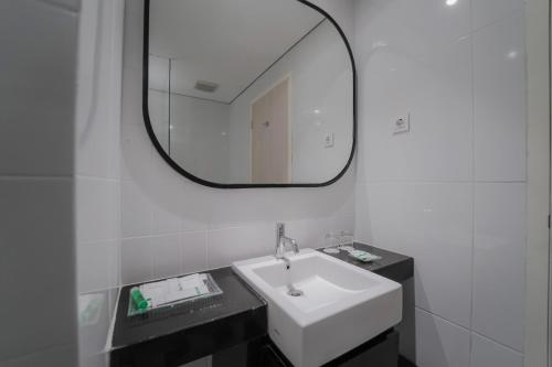 ein Badezimmer mit einem weißen Waschbecken und einem Spiegel in der Unterkunft Patra Bandung Hotel in Bandung