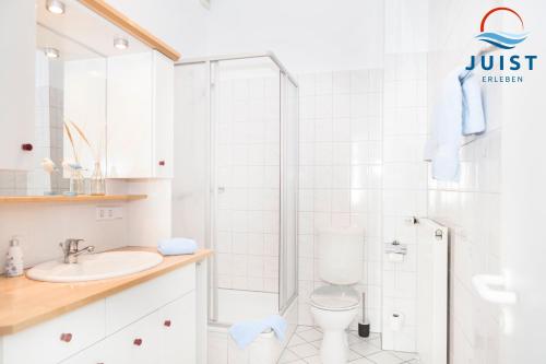 a white bathroom with a shower and a toilet at Pension Marie Luise 255 - Zimmer Kammmuschel in Juist
