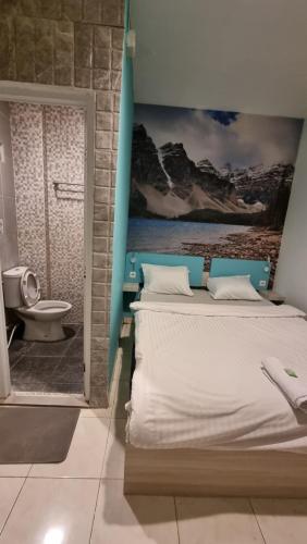 a bedroom with a bed and a bathroom with a toilet at Cozy centre Simpang Lima Semarang in Semarang