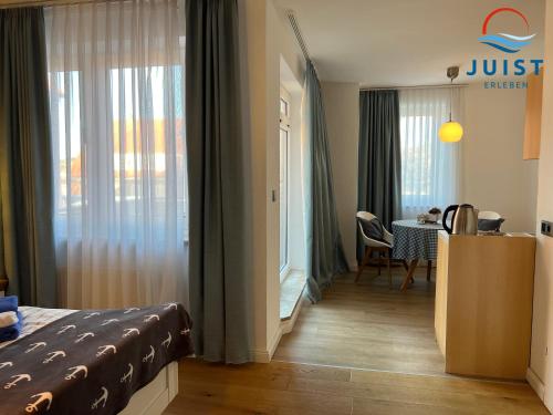 ユイストにあるPension Marie Luise 257 - Kombi-Zimmer Austerのベッドとダイニングルームが備わるホテルルームです。