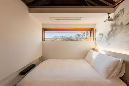 a bed in a small room with a window at Luxury hanok with private bathtub - SN18 in Seoul