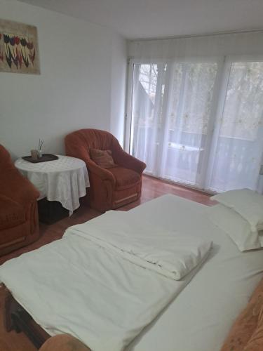 a bedroom with a bed and a chair and a table at Ana Lacramioara Concept in Călimăneşti