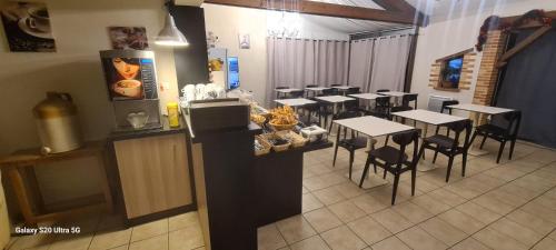 Un restaurante con mesas y sillas en una sala. en Hôtel Restaurant du Lac, en Graulhet