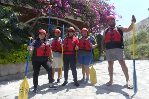 a group of people posing for a picture with paddles at Hostal Aventura Total Perú_lunahuana in Lunahuaná