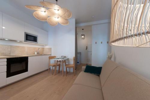 un salon avec un canapé et une cuisine avec une table dans l'établissement Le Cachat - hyper centre - wifi gratuit, à Évian-les-Bains