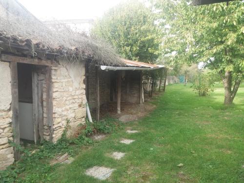 un ancien bâtiment en pierre avec un toit en gazon dans l'établissement Au numéro 4, à Paizay-le-Sec